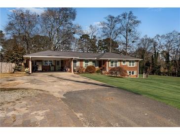 Charming brick home with a carport and well-manicured front yard at 4983 Arcado Sw Rd, Lilburn, GA 30047