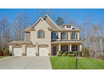 Charming two-story home boasts a well-manicured lawn and a three-car garage at 3610 Ansley Manor Ct, Cumming, GA 30028
