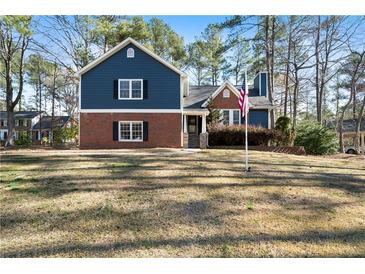 Charming two-story home with brick and blue siding, set on a spacious lawn with mature trees at 4970 Lost Mountain Nw Trce, Kennesaw, GA 30152