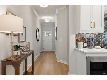 Bright entryway features wood floors, table with lamp, and direct access to the modern kitchen at 4521 Twinberry Dr, Powder Springs, GA 30127