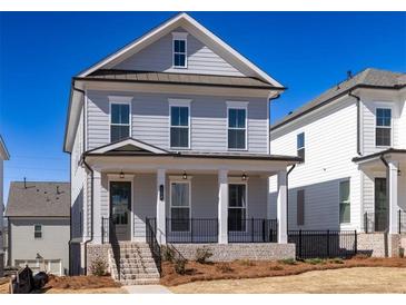 Charming two-story home with light blue siding, a covered front porch, and professionally landscaped yard at 104 Stonehouse Dr, Cumming, GA 30040