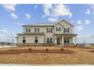 Charming two-story home featuring a symmetrical facade, complemented by dark shutters and a well-manicured front lawn at 267 Arwen Drive (Lot 66), Mcdonough, GA 30252