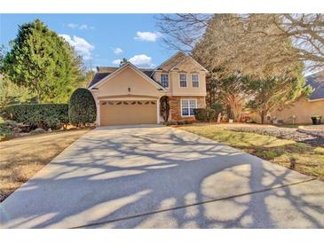 Charming two-story home with a well-manicured lawn, mature trees and a long driveway to a 2-car garage at 267 Windy Cir, Mcdonough, GA 30253