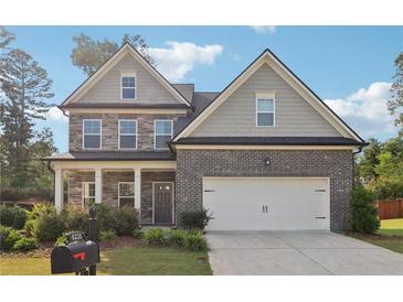 Charming two-story home with a brick exterior, well-manicured landscaping, and a two-car garage at 6235 Banyan Trl, Cumming, GA 30028