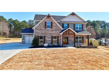 Two-story brick and siding home with a gable roof, attached garage, and a driveway at 3164 Rosebud Rd, Loganville, GA 30052