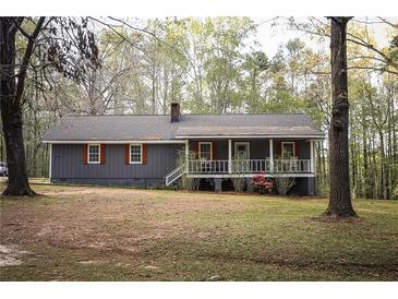 Charming exterior of a single-story home featuring a cozy front porch and manicured lawn at 823 Mount Tabor Rd, Oxford, GA 30054