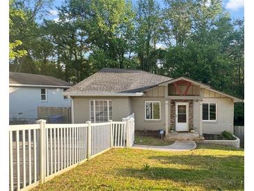 Charming home with neutral exterior, a well-maintained lawn, and a white picket fence at 1684 Braeburn Se Dr, Atlanta, GA 30316