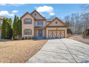Charming two-story home with well-maintained lawn, two-car garage, and inviting curb appeal at 6640 Grove Crossing Ct, Cumming, GA 30028