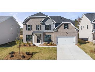 Charming two-story home with a brick facade, black shutters, and a well-manicured lawn, creating a welcoming curb appeal at 1861 Lacebark Elm Way, Lawrenceville, GA 30045