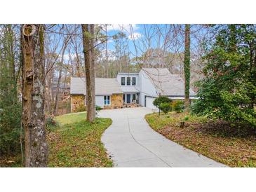 Charming home with a well-manicured front lawn and a long driveway leading to the entrance at 2590 Runic Way, Johns Creek, GA 30022