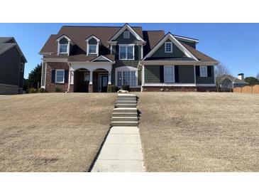 Charming two-story home with a mix of brick and siding, complemented by a well-manicured lawn at 3817 Bay Orchard Ln, Loganville, GA 30052
