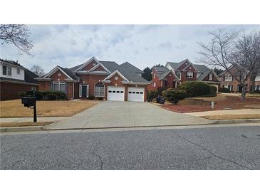 Charming single-story brick home features a manicured lawn and two-car garage at 2604 Harman Park Cir, Duluth, GA 30097