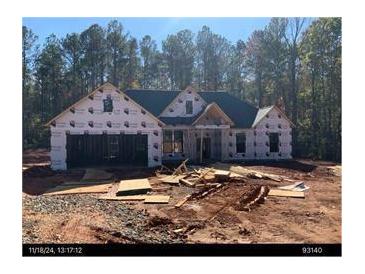 New construction featuring an attached two-car garage and a modern roofline, surrounded by a wooded lot at 247 Harmony Ridge Dr, Temple, GA 30179