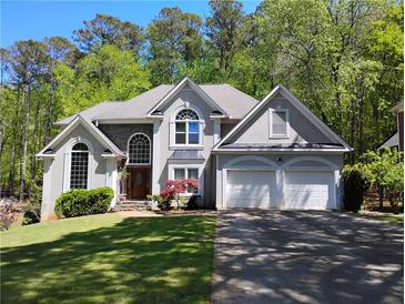 Charming two-story home with a manicured lawn, an attached two-car garage, and mature trees at 1470 Sweet Bottom Sw Cir, Marietta, GA 30064