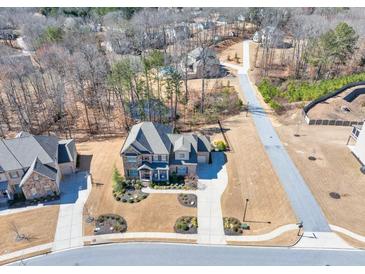 Stunning aerial view of a two-story home with a well-manicured lawn and tree-lined street at 4590 Gablestone Xing, Hoschton, GA 30548