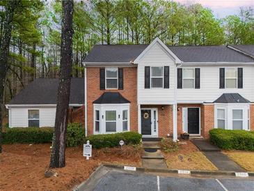 Charming townhome featuring a brick facade, bay window and well-maintained landscaping at 2958 Stonecrest Ln, Lithonia, GA 30038