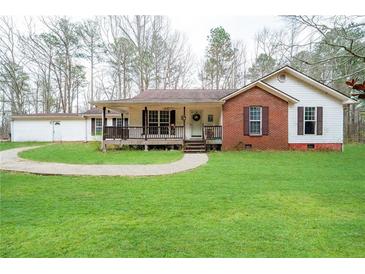 Charming home with inviting front porch and well-maintained lawn in a serene setting at 8951 Brewer Rd, Douglasville, GA 30134