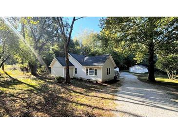 Charming single-story home featuring a cozy layout and surrounded by mature trees at 8083 Highway 166, Douglasville, GA 30135