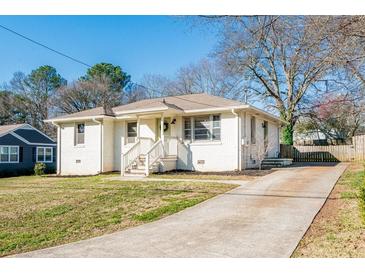 Charming white brick home featuring a well-maintained lawn and inviting front porch at 2976 Emory Se Rd, Smyrna, GA 30080