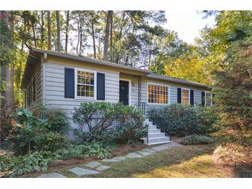 Charming home featuring stone walkway, landscaped front yard, and cozy, neutral colored exterior at 1031 Lindridge Ne Dr, Atlanta, GA 30324