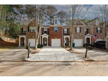 Inviting townhome exterior featuring a well-manicured lawn and private driveways at 1290 Adcox Sq, Stone Mountain, GA 30088