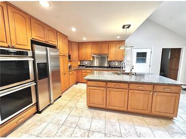 This kitchen has wood cabinets, stainless steel appliances, a tile backsplash, and granite countertops at 4341 Kings Ne Way, Marietta, GA 30067
