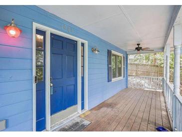 Inviting front porch with a blue door, vintage lighting, and a wood-planked floor at 1083 Lake Dr, Snellville, GA 30039