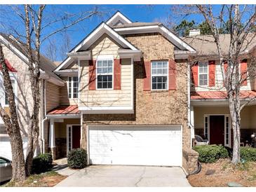 Charming townhome showcasing a brick facade, complemented by a one-car garage and well-maintained landscaping at 386 Creek Manor Way, Suwanee, GA 30024