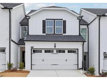 Charming two-story home with a white painted brick exterior and a two car garage at 1705 Trout Lily Pl, Smyrna, GA 30126