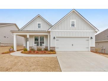 Charming one-story home with a well-manicured lawn and covered porch with rocking chairs at 124 Redford Ln, Canton, GA 30115