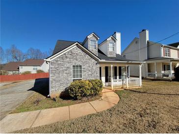 Charming front exterior with stone facade, dormer windows, and cozy front porch at 916 Hunt Rd, Jonesboro, GA 30236