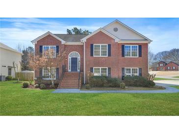 Charming two-story brick home featuring a well-manicured lawn and inviting front entrance at 439 Wind Walk Cir, Lawrenceville, GA 30044