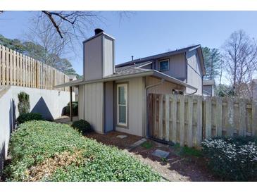 Charming townhome featuring neutral siding, chimney, privacy fence and mature landscaping, creating a cozy outdoor space at 426 Manning Villas Ln, Marietta, GA 30064