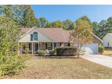 Charming single-story home with a well-maintained front yard and attached two car garage at 320 Creekside Trl, Covington, GA 30016