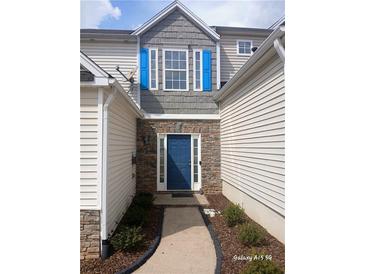 Charming home featuring a blue front door, stone accents, and light-colored siding, creating a welcoming entrance at 1510 Paramount Ln, Sugar Hill, GA 30518