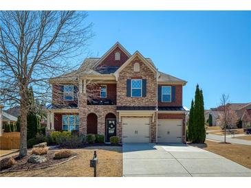 Charming two-story brick home with a well-manicured lawn, two car garage and stone accents at 6125 Allison Rd, Cumming, GA 30040