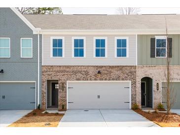Charming townhome exterior featuring a brick facade and attached garage at 412 Carrera Ln, Acworth, GA 30102