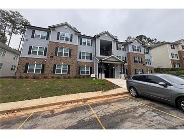 Apartment building exterior with brick and siding, black shutters, and visible parking area at 3204 Fairington Village Dr, Lithonia, GA 30038