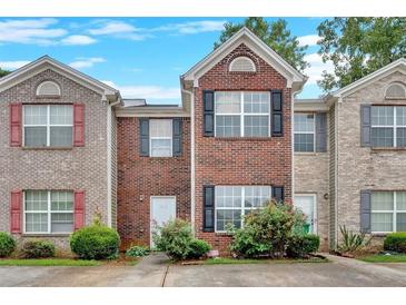Charming brick townhome featuring black shutters, a gabled roof, and inviting curb appeal at 1573 Eastern Sunrise Ln, Decatur, GA 30034