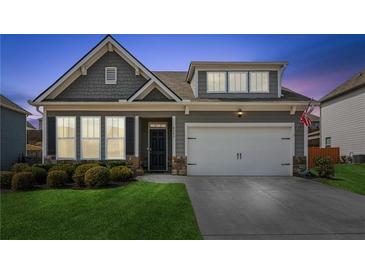 Charming home featuring a two-car garage, well-manicured lawn, and neutral exterior paint at 4645 Dandelion Way, Cumming, GA 30040