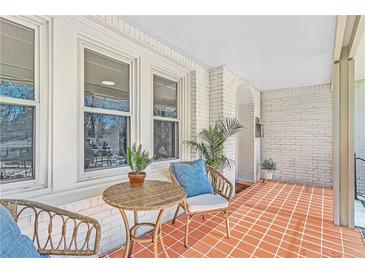 Inviting covered porch featuring wicker furniture, brick accents, and ample natural light for outdoor relaxation at 1337 M L King Jr Nw Dr, Atlanta, GA 30314