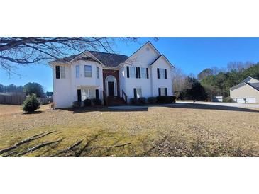 Charming two-story home with black shutters and a well-manicured lawn at 903 Tucker Ln, Loganville, GA 30052