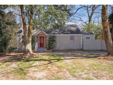 Charming one-story home with grey brick, red front door, and mature trees at 1922 Willa Dr, Decatur, GA 30032