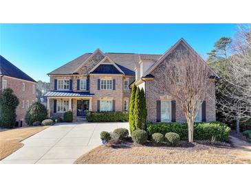 Beautiful brick home with manicured landscaping, and a concrete driveway at 4360 Autry Way, Alpharetta, GA 30022