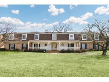 Expansive two-story home with a long front porch, manicured lawn, and mature trees at 3825 Lavista Rd # Q3, Tucker, GA 30084