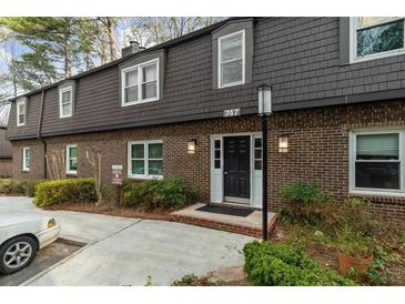 Charming brick townhouse featuring a black front door and a well-maintained front yard at 747 Houston Mill Ne Rd # 1, Atlanta, GA 30329
