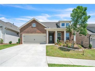 Charming brick home with a two-car garage, manicured lawn, and inviting front entrance at 163 Lorraine Pkwy, Woodstock, GA 30188