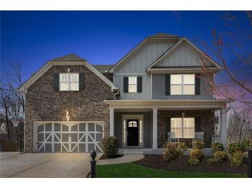 Charming two-story home featuring a brick and siding exterior, covered porch, and well-manicured front yard at 6350 Boulder Rdg, Cumming, GA 30028