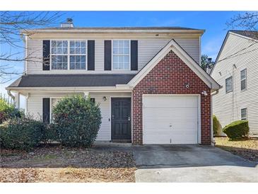 Charming two-story home features a brick accent wall, a front-entry garage, and a well-maintained front yard at 7013 Mahonia Pl, Lithonia, GA 30038