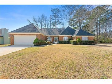 Charming single-story brick home featuring manicured landscaping and attached two car garage at 4184 Wyndham Park Cir, Decatur, GA 30034
